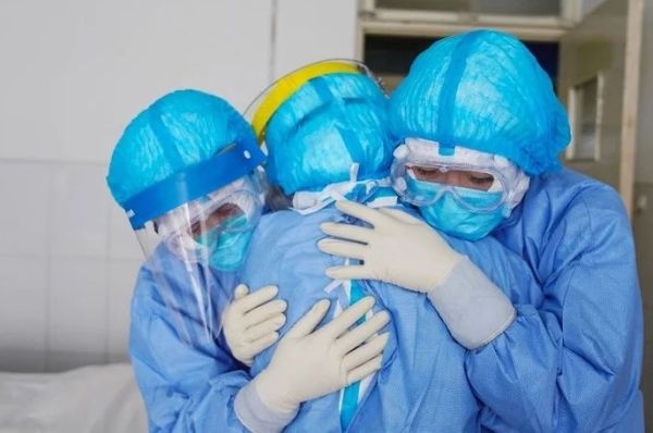 Membros da equipe médica se abraçando em uma ala de isolamento em um hospital em Zouping, no leste da China. 