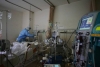 Trabalhador médico atende um paciente com coronavírus no Hospital da Cruz Vermelha em Wuhan, na China