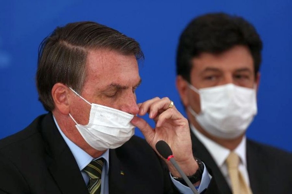 O presidente Jair Bolsonaro e o ministro da Saúde, Luiz Henrique Mandetta, usam máscaras em coletiva sobre o coronavírus no Brasil